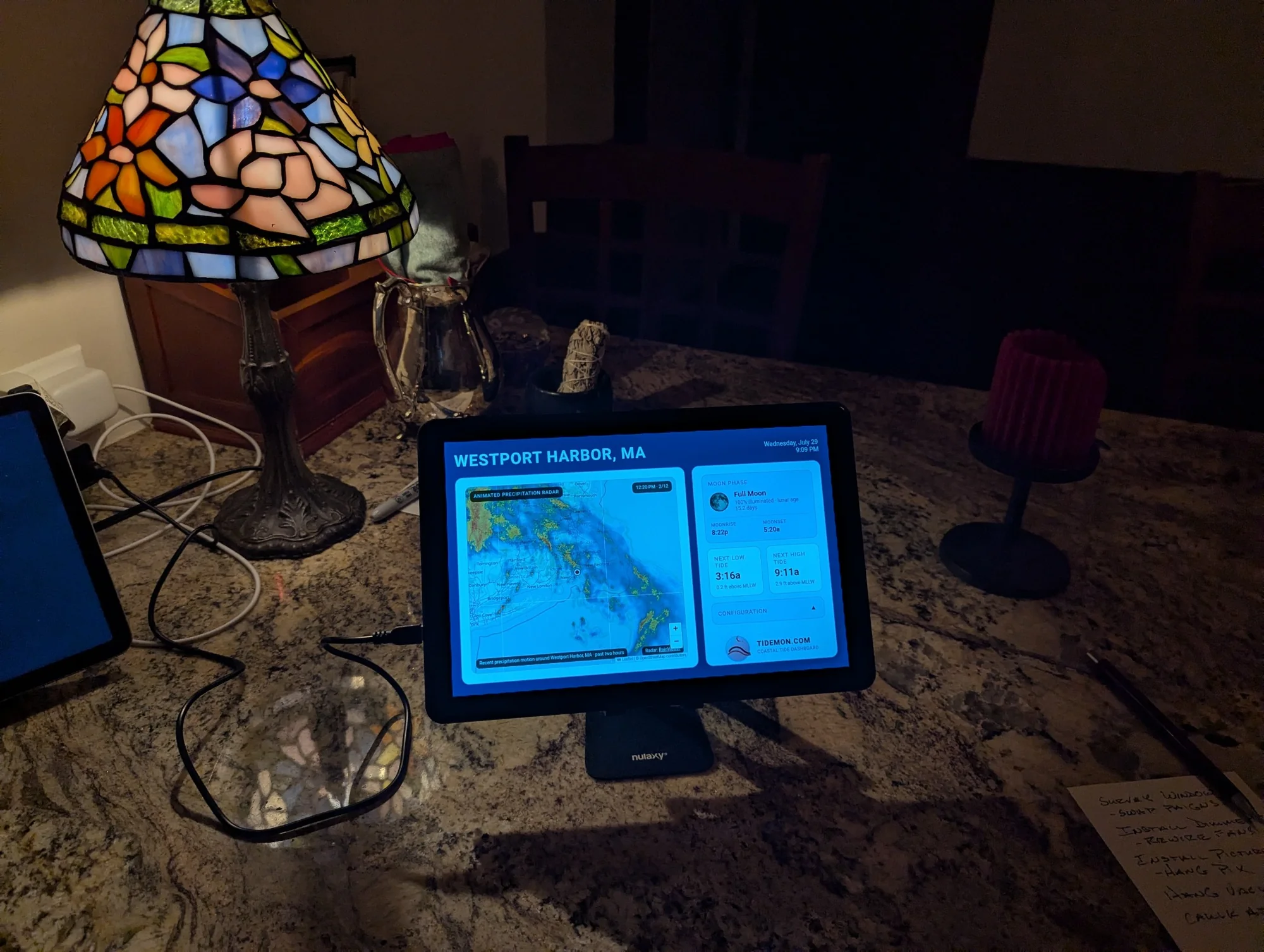 The actual TideMon tablet on a desktop stand showing a coastal dashboard